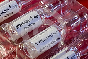 Detailed shot of a 1 mg ml vial of morphine sulfate for injections or infusions, set against a vivid red backdrop