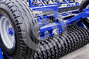 Detailed shot of a modern plow with metal discs and tires for efficient farming, highlighting agricultural machinery innovation