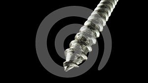 Detailed shot of a steel screw screw or metal bolt rotating on an isolated black background. Helix thread super macro
