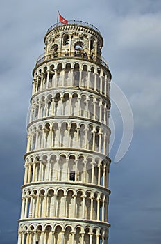 Detailed view of ancient Leaning Tower of Pisa against stormy sky and gloomy clouds. Notable landmark of Pisa