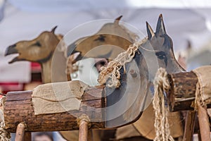 Detailed view of archaic wood horses toys on carousel