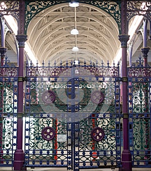 Detailed view of colourful wrought ironwork gate at Smithfield meat and poultry market in the City of London, UK.