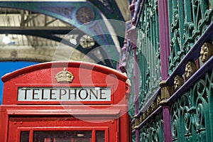 Detailed view of the colourful wrought ironwork and red telephone box at Smithfield meat market, London UK