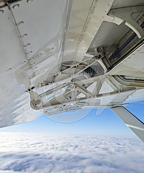 Detailed view of flaps , high-lift devices and actuators of a general aviation airplane flying at stall speed. Strut and wing of