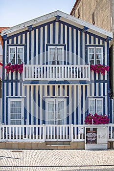 Detailed view of front facade windows and balcony with flowers of typical Costa Nova beach house