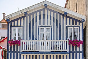 Detailed view of front facade windows and balcony with flowers of typical Costa Nova beach house