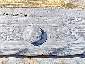 Detailed View of Hand Forged Iron Strap Hinge and round rivet. Close-up of a rustic iron hinge with a hammered texture