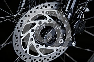 Detailed view of a motorcycles front wheel, showcasing the tire, rim, spokes, and brake caliper with disc rotor