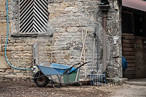 Detailed view outside a stable and livery block showing various tools used to clean out the horse stables.