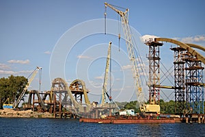 Detailed view the process of mounting steel structures for construction of a new pedestrian bridge over river