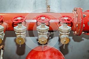 Detailed view of red old fire pump pipe with small valve stopcock