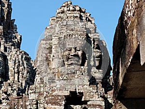 Detailed view of stone human faces adorning the towers of the Bayon Temple, a Khmer site in Cambodia