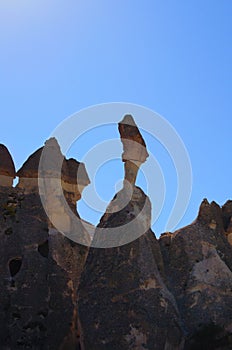 Detailed view top of the famous Fairy Chimneys or Multihead stone mushrooms in Pasaba Valley near Goreme. Blue sky background.