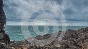 Detailed view of volcanic coastline with high cliffs and waves breaking over volcanic rocks, Portugal.