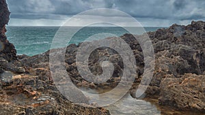 Detailed view of volcanic coastline with high cliffs and waves breaking over volcanic rocks, Portugal.