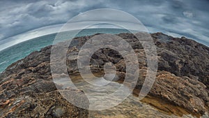 Detailed view of volcanic coastline with high cliffs and waves breaking over volcanic rocks, Portugal.