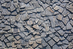 Detailed view of wall texture randomly lined with slate panels, typical and traditional shale stone material, used as external
