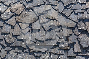Detailed view of wall texture randomly lined with slate panels, typical and traditional shale stone material, used as external