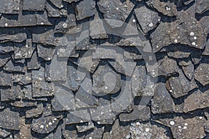 Detailed view of wall texture randomly lined with slate panels, typical and traditional shale stone material, used as external