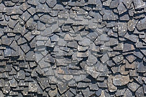 Detailed view of wall texture randomly lined with slate panels, typical and traditional shale stone material, used as external