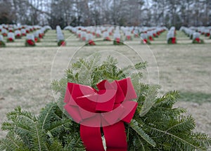 Detailed view of a wreath that has been placed on all graves in a military cemetery.
