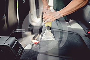 detailing and car care concept - Professional using steam vacuum for draining stains