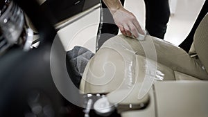 Detailing and cleaning of back seats at luxury modern car. Car interior washing. Car dealership dry cleaning.