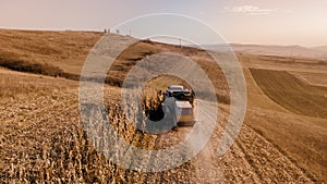 Details of autumn harvest. Aerial view of combine harvesting over the hills