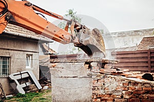 Details of backhoe excavator scoop demolishing ruins, destroying and loading debris photo