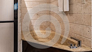 Details of the bathroom interior. A beige triangular bathtub