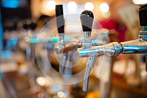 Details of the beer bar. Beer taps in a row in perspective. Warm tinting, different focus.  Close up of beer Tap. Selective focus.