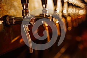 Details of the beer bar. Beer taps in a row in perspective. Warm tinting, different focus.  Close up of beer Tap. Selective focus.