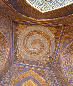 Blue interior of dome with gold gild of Tile Karl Madrasa in The photo