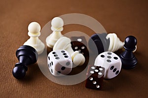 Details of the board game dice and chess pieces close-up lie on the brown table. Play board games