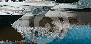 Details of boats on water, with reflection