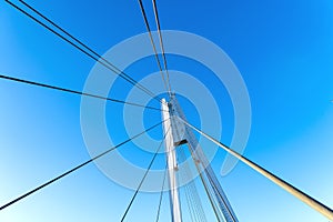 Details of the cable-stayed bridge against the background of the blue sky.