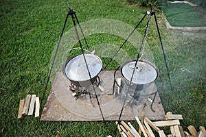 Details with cast iron cauldrons and firewood prepared for an outdoor cooking session