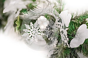 Details of Christmas tree decor in white close-up and copy space. Christmas tree branches and white toys with empty space. Snowfla