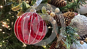 Details of christmas tree with red bauble and pine cone