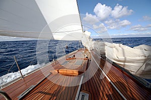 Details of a classic wood sailboat in open waters.