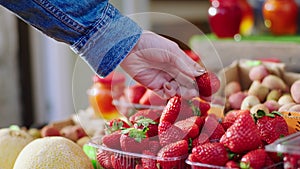 Details closeup fresh vegetables shop customer pick up some fresh strawberry and analysing them concept of farming and