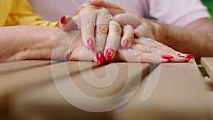 Details closeup old woman hands at the cafe in the middle of the park