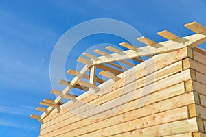 Details of construction wooden house on bule sky background, roofing timber structure system.