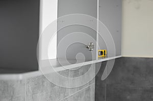 Details of custom kitchen cabinets. Gray modular kitchen from chipboard material on a various stages of installation in