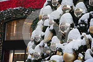 Details decorated Christmas tree with silver balls, snow, garland. Shopping in city. Outdoor fair. Xmas card and pattern