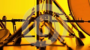 Details of a drum kit on a bright yellow background. Double pedals, hi-hat and snare stand in close up. Glossy, shiny, chrome