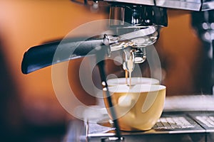 Details of espresso machine pouring and brewing fresh, creamy coffee in local bistro, restaurant or pub