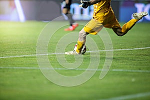 Details with the feet of a soccer goalkeeper kicking the ball during a match