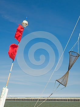 Details of a fishing boat: buoys with red flags and fishing net