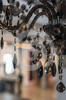 Details of a glass chandelier with a blurred room in the background.